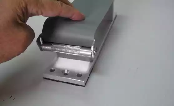 The edge of the sandpaper is inserted between wedge rollers here.